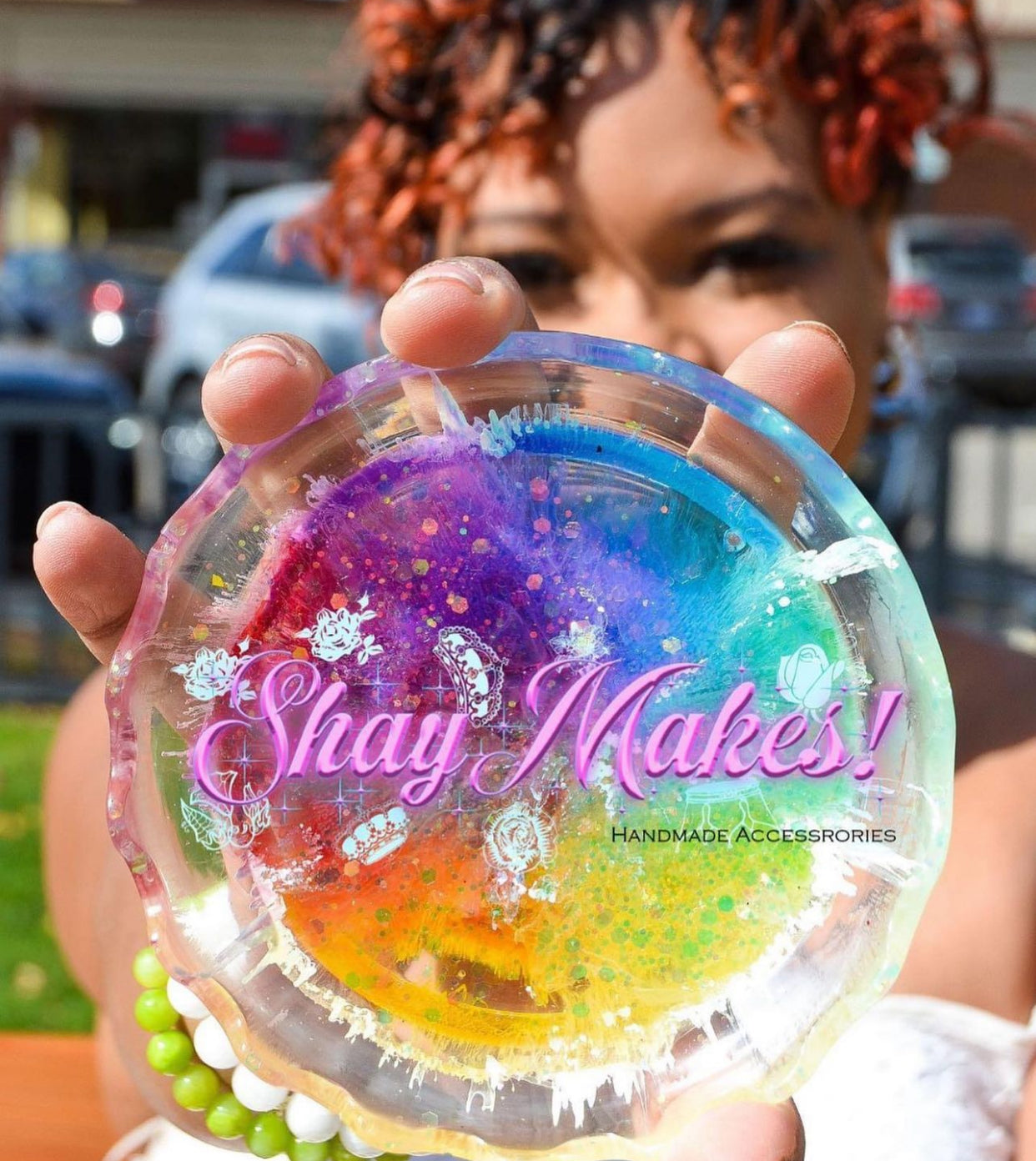 Woman holding a colorful resin coaster with 'Shay Makes!' branding.